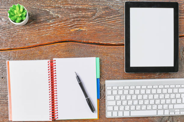istock Laptop, tablet and notebook are on a wooden table 971430408