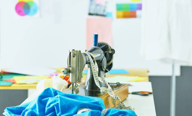 istock Retro sewing machine on designer clothes desktop 971433140