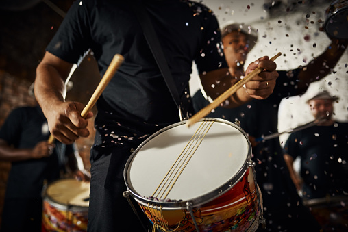 Closeup shot of a musical performer playing drums with his band