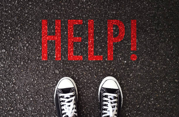 istock Black shoes standing at the road with help wording. 971433972