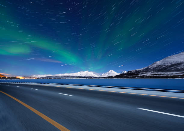 istock Motion Highway at Green Aurora Borealis and Midnight Galaxy Sky 971437474