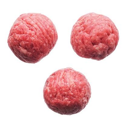 Food: three fresh uncooked homemade meatballs, isolated on white background
