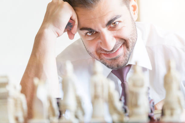 Businessman playing chess and smiling