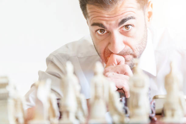 Businessman playing chess and staring at the camera