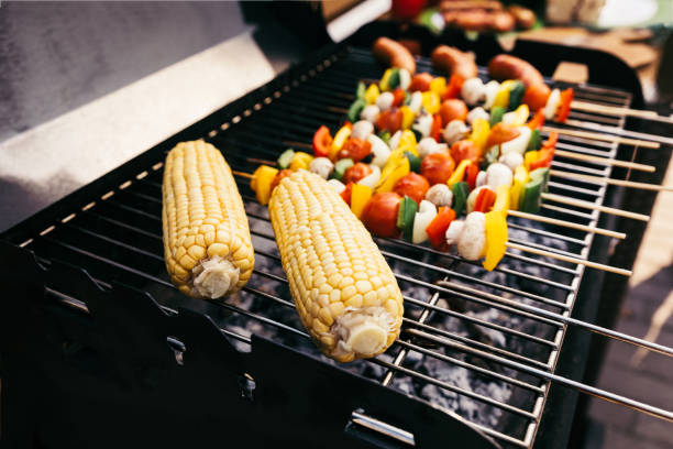 istock Corn cobs and vegetables on skewers cooked outdoors on grill 971503390