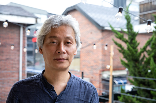 Korean man, relaxed portrait at home looking at camera