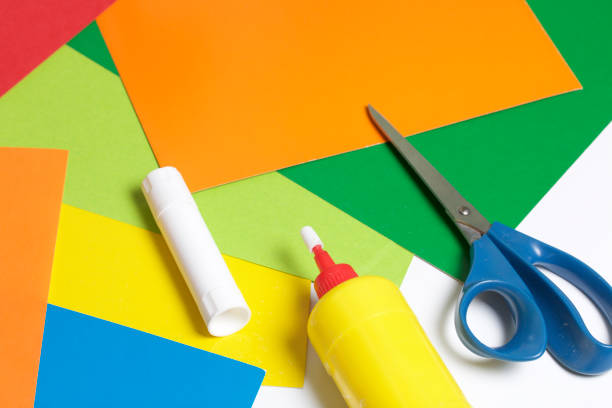 istock Lessons in applique. Necessary items: glue, colored paper and scissors lie on the white surface of the table. 971503736