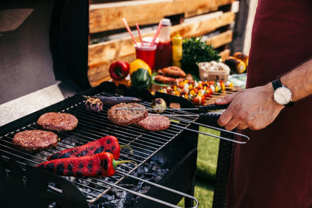 istock Chef cooking patties and vegetables grilled for outdoors barbecue 971503924