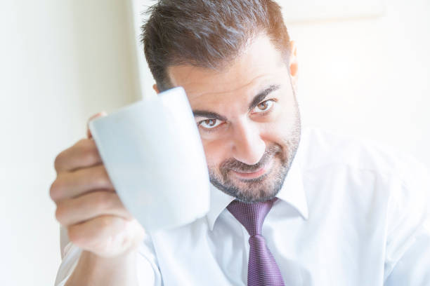 Businessman drinking coffee and looking at the camera