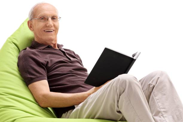 istock Senior with a book sitting on a beanbag 971534286