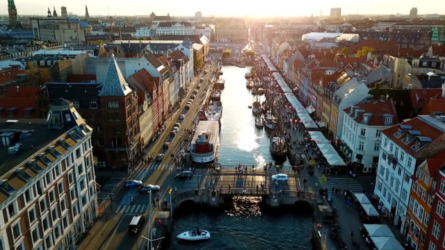 Amzing Backlight sunset footage from Copenhagen, Denmark. bridge in Nyhavn New Harbour canal and entertainment district. Aerial Video footage view from the top. forward movement. Sunset golden light