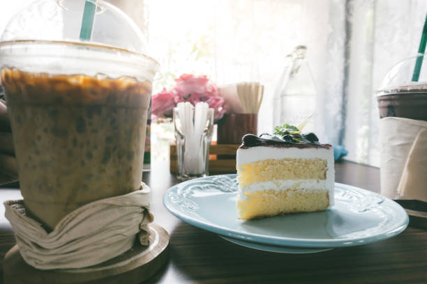 cake and iced coffee in a cafe on a wooden table by a window.