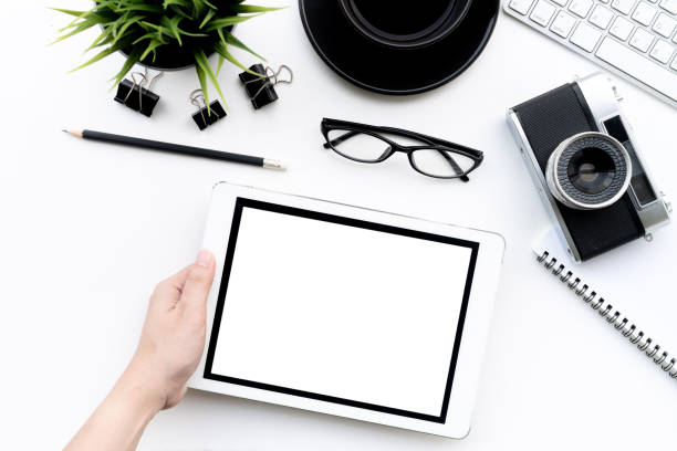 istock Flat lay of top view Business woman use tablet on modern white desk work table with computer laptop,retro film camera and stationary in home office includes copyspace for add text or graphic 971553518