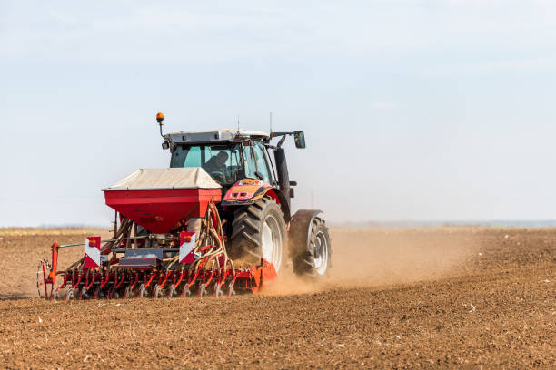 istock Farmer seeding, sowing crops at field. 971556858