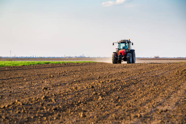 istock Farmer fertilizing arable land with nitrogen, phosphorus, potassium fertilizer 971556978