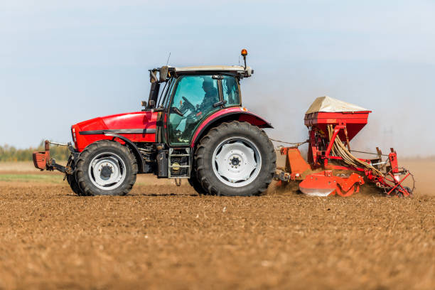 istock Farmer seeding, sowing crops at field. 971559822