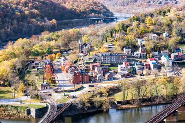 Harper's Ferry overlook closeup of cityscape with colorful orange yellow foliage fall autumn forest with small village town by river in West Virginia, WV