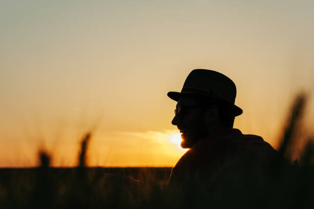 istock Young man resting in the wheat field at the sunset 971582348