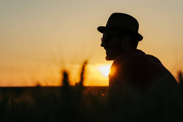 istock Young man resting in the wheat field at the sunset 971582354