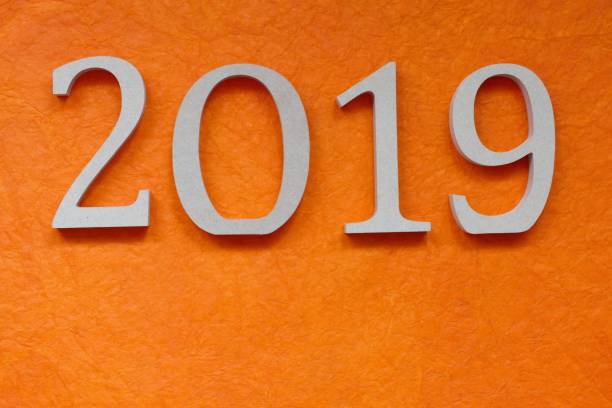 istock Year 2019 as wooden numbers on orange background 971583838