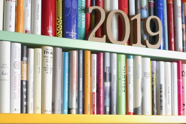 istock Year 2019 as wooden numbers standing on library shelf 971583898