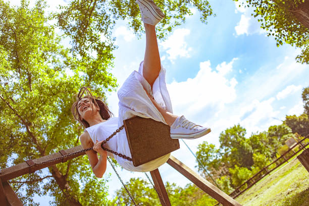 istock Happy young woman on the swing 971589678
