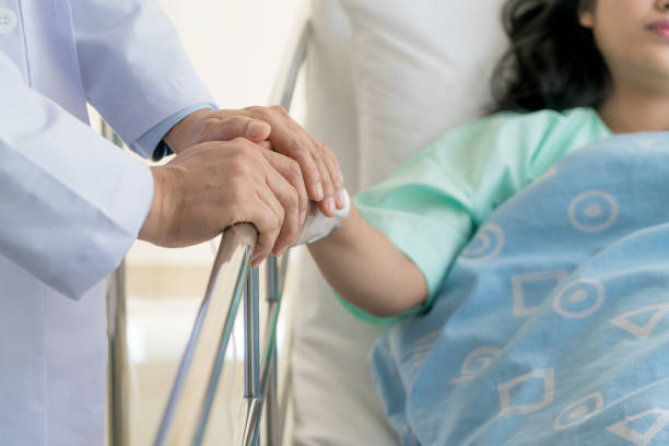 friendly man doctor hands holding patient hand sitting at the desk for encouragement, empathy, cheering and support while medical examination. bad news lessening, trust and ethics concept - trust imagens e fotografias de stock