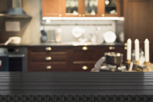 istock Blurred abstract background. Modern dark kitchen interior with tabletop for background and space for you. 971593860