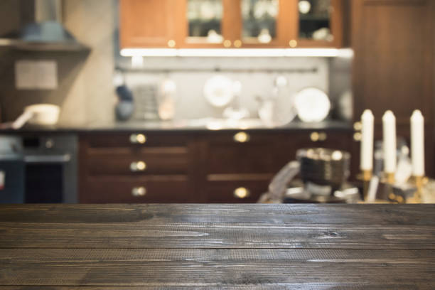 istock Blurred abstract background. Modern dark kitchen interior with tabletop for background and space for you. 971593886