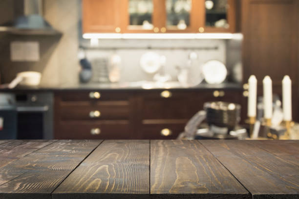 istock Blurred abstract background. Modern dark kitchen interior with tabletop for background and space for you. 971593888