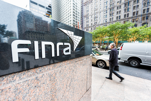 New York City, USA - October 30, 2017: Sign on the building of Financial Industry Regulatory Authority, or Finra, in Manhattan NYC lower financial district downtown, businessman man walking