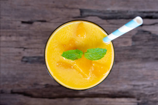 istock Mango smoothies  juice and fruit mango  from the wood background from the top view. 971637152