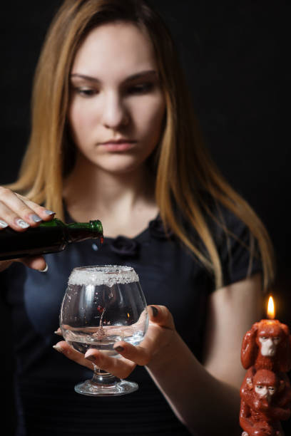 A young girl prepares a hot cocktail of gin