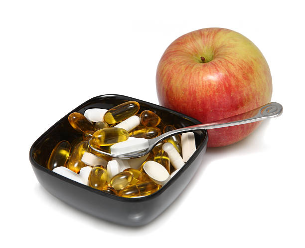 istock Red Fuji apple with pills in black bowl 97166725