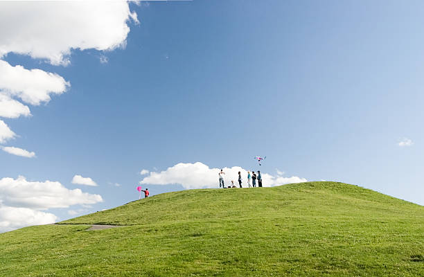 Flying a kite on hill with blue sky and clouds stock photo