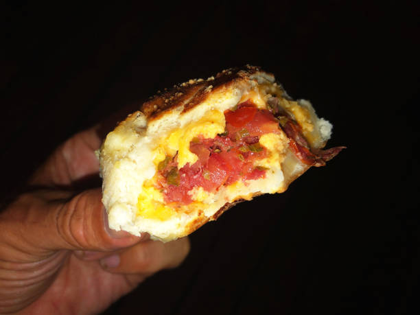 istock Hand Holding Savory Pizza Roll at Night 971686206