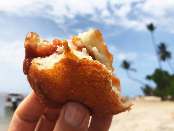 istock Hand Holding Sweet Doughnut on the Beach 971686216