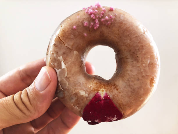 Hand Holding Gourmet Rose Flavored Donut