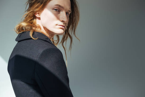 istock handsome man with long hair posing in black jacket, on grey 971703792