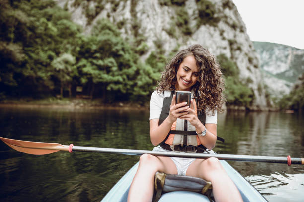 ragazza carina che fa selfie durante il viaggio in kayak sul lago - extreme sports kayaking kayak adventure foto e immagini stock