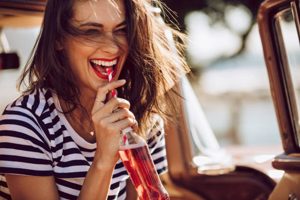 mujer en coche disfrutando de beber cola - drinks fotografías e imágenes de stock