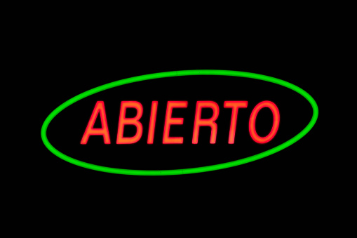 A green oval neon with another red neon inside shaped in the Spanish word 