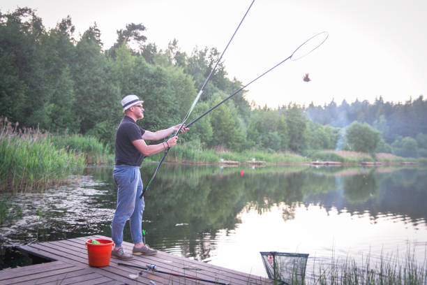 istock Man fishing rod catches fish. 971741960