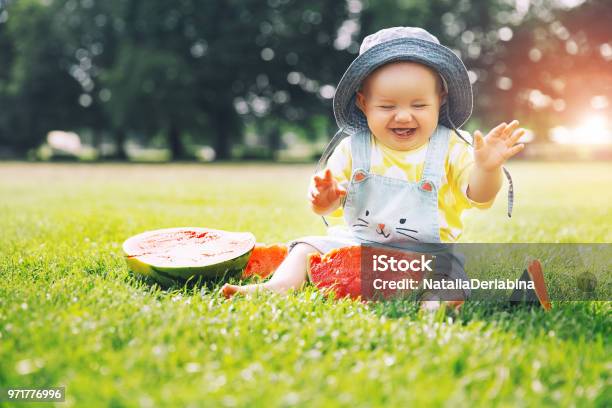 Más Lindo Sonriente Niña Comiendo Sandía Sobre Hierba Verde Durante El Verano Foto de stock y más banco de imágenes de Bebé