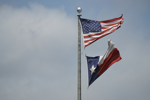 This is a view of a United States flag flown on Virginia Beach as seen from a public road.