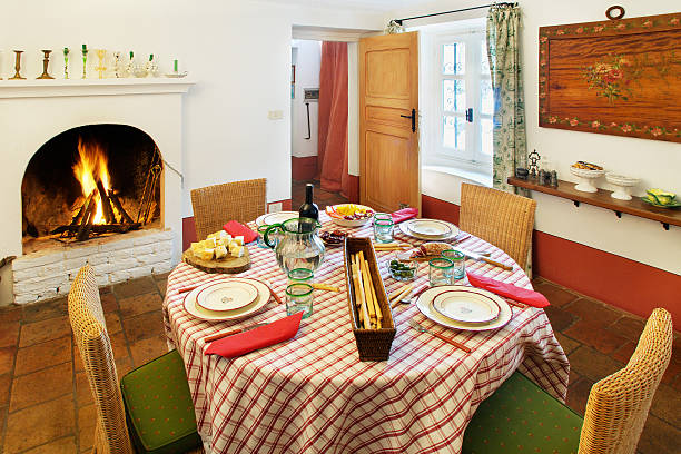 istock Rustic dining room: terracotta floor, fireplace, set table, straw chairs 97178883