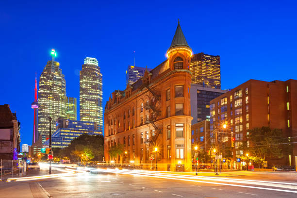 Downtown Toronto Ontario Canada Long exposure stock photograph of cars passing in front of the Gooderham Building, an old office building on Front street in downtown Toronto, Ontario, Canada at twilight blue hour. flatiron building toronto stock pictures, royalty-free photos & images