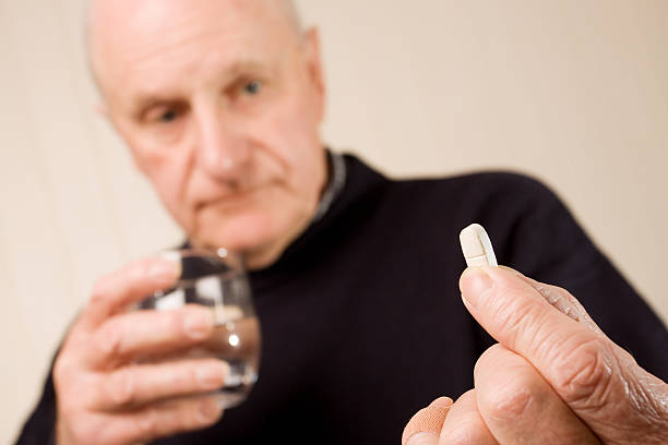 istock Senior older man holding tablet or pill with water 97180591