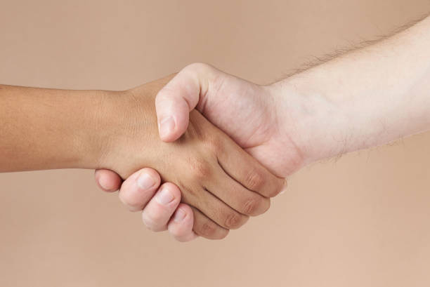 istock Black and white skin people handshake 971819740