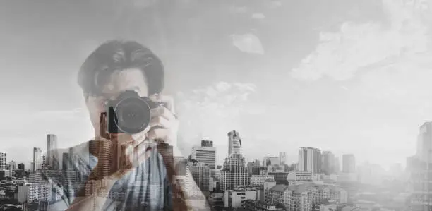Photo of Double exposure, a man taking photography and black and white city background
